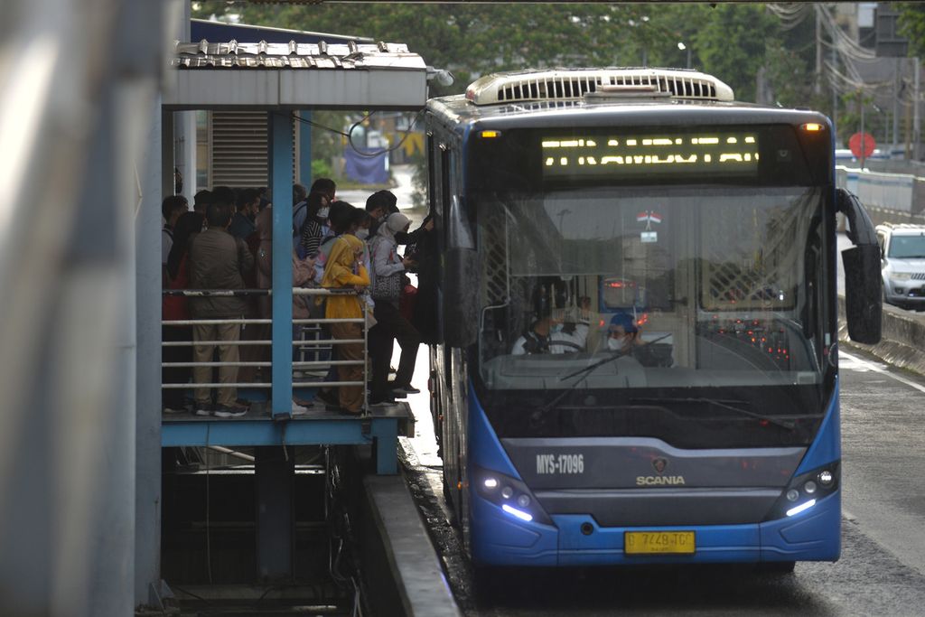 Warga berdesakan untuk masuk ke dalam bus Transjakarta di Halte Harmoni, Jakarta Pusat, Jumat (16/12/2022).