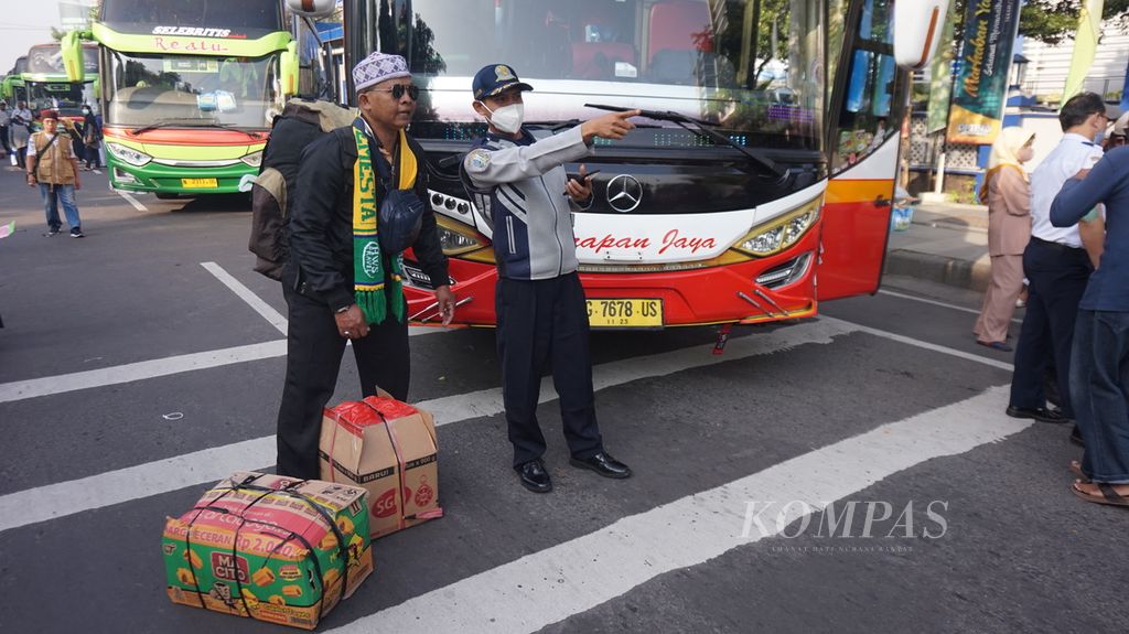 Penumpang peserta program mudik gratis Pemerintah Provinsi Jawa Timur bertanya kepada petugas Dinas Perhubungan untuk mencari bus yang akan dinaikinya menjelang keberangkatan dari Surabaya, Rabu (19/4/2023). Sebanyak 3.600 warga diberangkatkan dengan 90 bus mudik gratis.