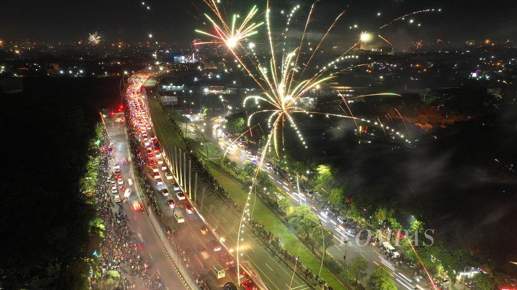Warga merayakan pergantian Tahun Baru dengan menyalakan kembang api di Jalan Ahmad Yani, Kota Bekasi, Jawa Barat, Minggu (1/1/2023). 