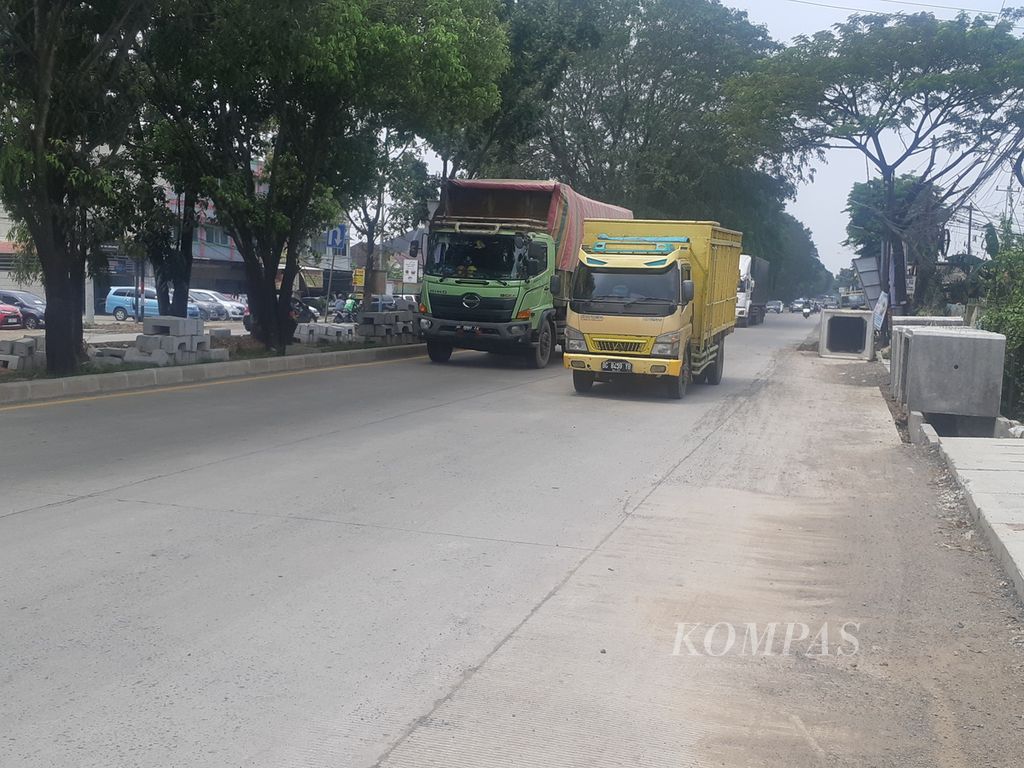 Dua truk melintas di Jalan Alamsyah Ratu Prawiranegara, Palembang, Kamis (13/4/2023). Jalan nasional ini merupakan satu dari empat proyek kerja sama pemerintah dengan badan usaha (KPBU) yang tengah dijalankan. Upaya ini dilakukan untuk mengurangi risiko kerusakan jalan dengan menekan biaya yang dikeluarkan oleh APBN.