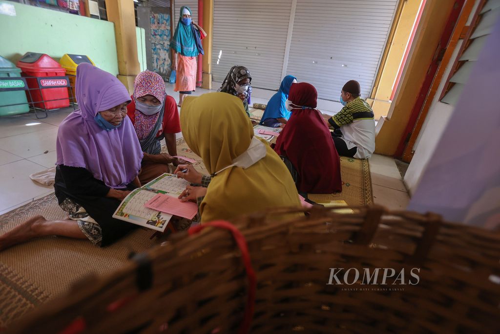 Buruh gendong mengikuti kegiatan pelatihan membaca Al Quran di Pasar Beringharjo, Yogyakarta, Jumat (8/4/2022). Pelatihan untuk buruh gendong tersebut digelar setiap bulan Ramadhan. 