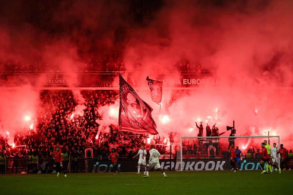 Suporter Rennes menyalakan kembang api saat pertandingan babak <i>playoff </i>Liga Europa antara Rennes dan AC Milan di Stadion Roazhon Park, Rennes, Perancis, Jumat (23/2/2024) dini hari WIB.