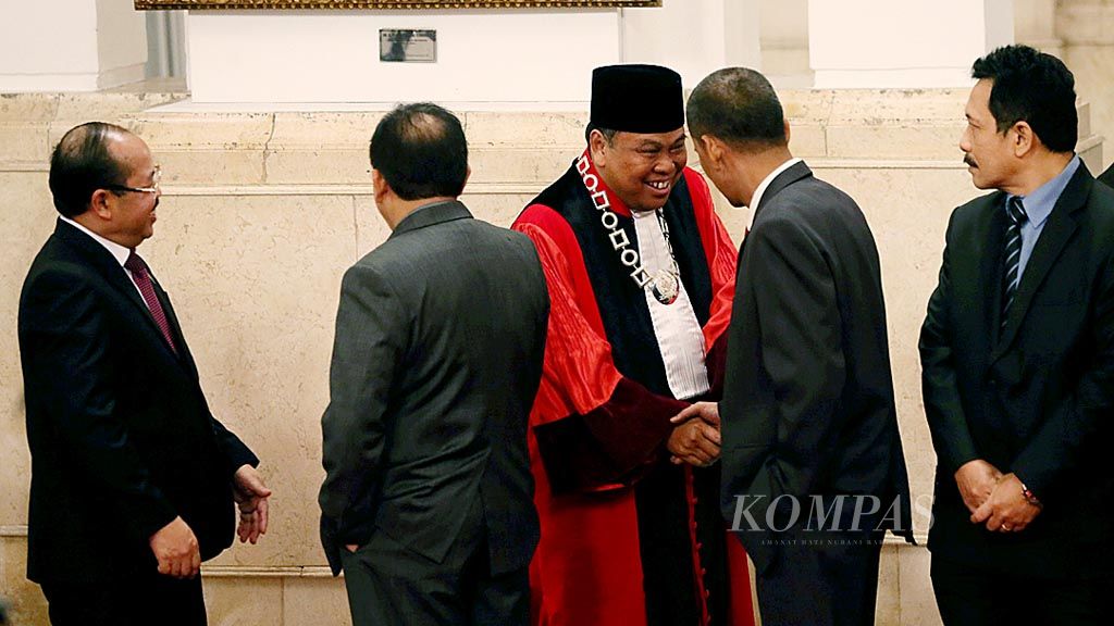 Arief Hidayat menjabat tangan hakim konstitusi   lainnya saat menunggu dimulainya acara pengucapan sumpah jabatan hakim konstitusi di depan Presiden yang dilaksanakan di Istana Negara, Jakarta, Selasa (27/3). Arief kembali menjadi hakim konstitusi periode 2018-2023 setelah ditetapkan oleh DPR.