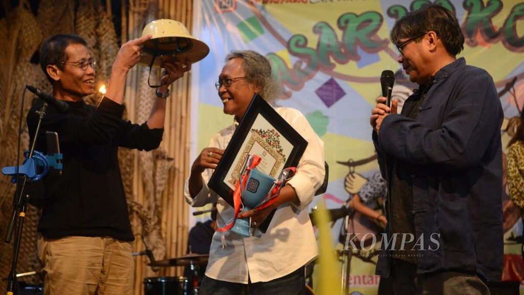 Direktur Bentara Budaya Frans Sartono memberikan penghargaan kepada pensiunan wartawan harian <i>Kompas,</i> Thomas Pudjo (tengah), dalam acara peringatan HUT Ke-36 Bentara Budaya di Bentara Budaya Yogyakarta, Rabu (26/9/2018) malam. .