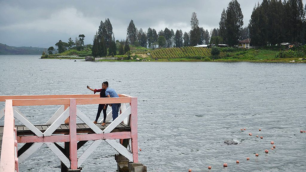 Warga menikmati pemandangan di Danau Atas, Kabupaten Solok, Selasa (23/1).