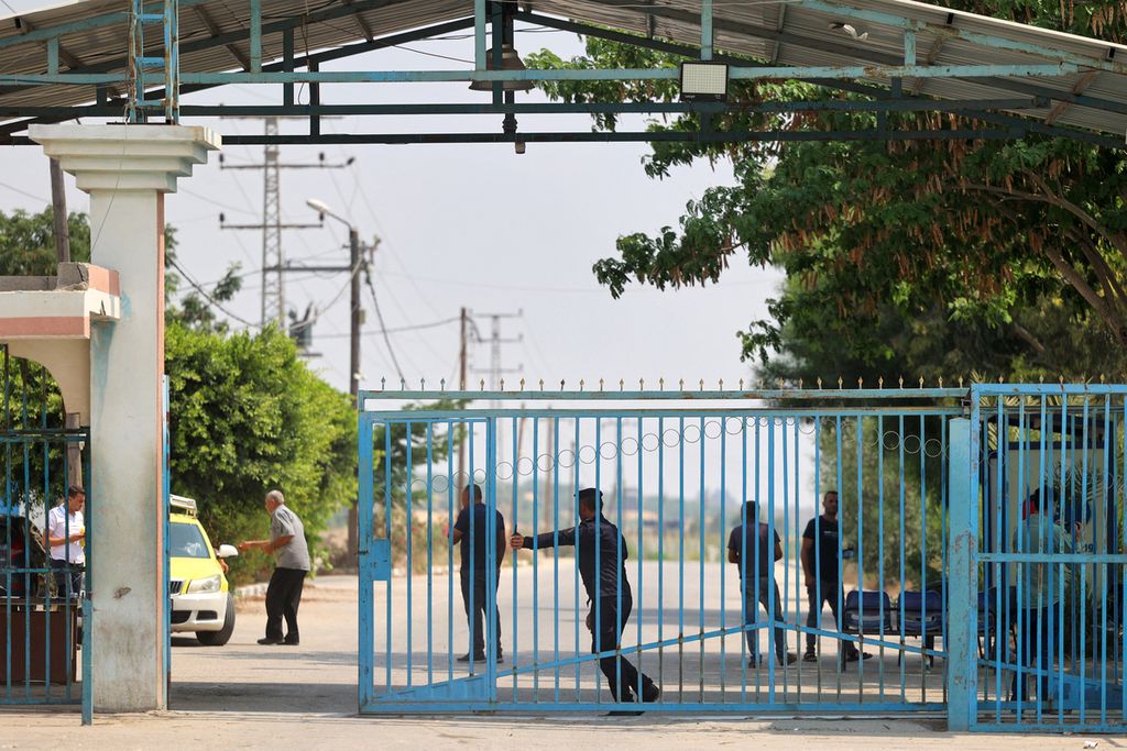 Seorang polisi Palestina mendorong pagar gerbang perbatasan Palestina-Israel Beit Hanun, Kamis (4/8/2022). Israel menutup perbatasan dengan Palestina karena khawatir tindakan balasan kelompok Jihad Islam. 