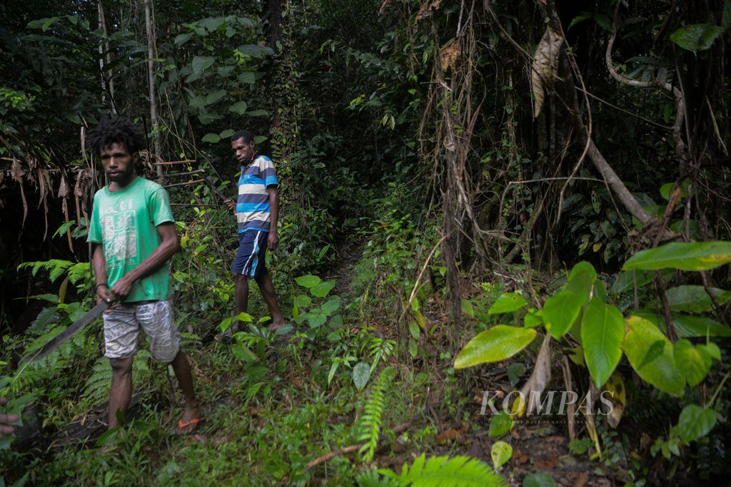 Warga menyusuri hutan desa di Kampung Sira, Sorong Selatan, Papua Barat, Rabu (9/6/2021). Masyarakat desa itu dipercaya mengelola hutan desa yang terus dijaga kelestariannya di sekeliling pemukiman mereka.