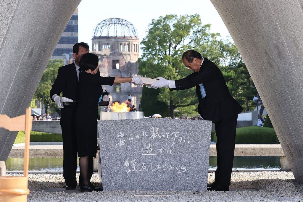 Wali Kota Hiroshima Kazumi Matsui (kanan) dan perwakilan keluarga menempatkan daftar korban bom nuklir di monumen dalam upacara peringatan ke-78 tahun serangan bom atom pertama di Hiroshima, Jepang, Minggu (6/8/2023). 