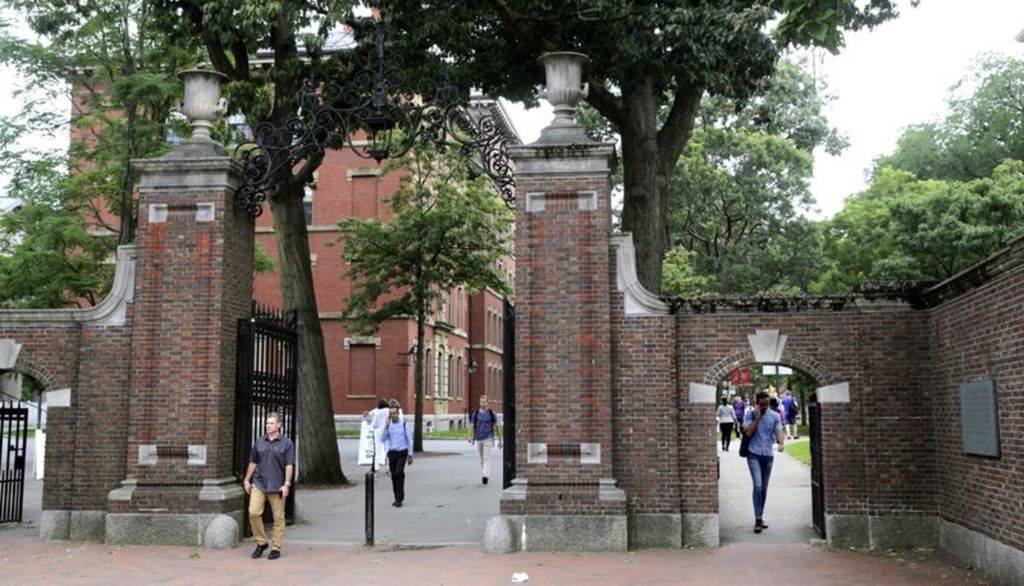 Pejalan kaki berjalan di gerbang Harvard Yard di Harvard University di Cambridge, Massachusetts, 13 Agustus 2019.