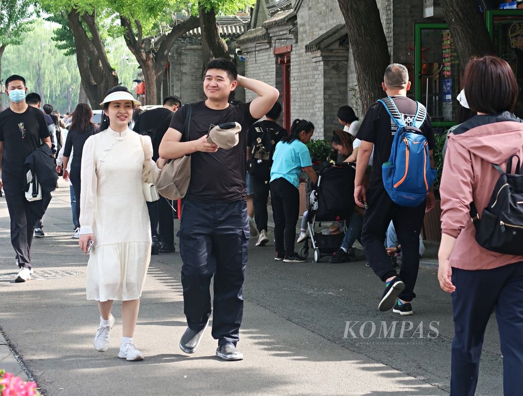 Seorang perempuan (kiri) terlihat mengenakan <i>qipao</i> atau <i>cheongsam</i> saat berkunjung ke Shichahai, di Distrik Xicheng, Beijing, China, Selasa (2/5/2023). Gerakan neo-China terlihat dalam busana perempuan muda di jalanan China. Mereka memadukan baju tradisional dengan sentuhan modern.
