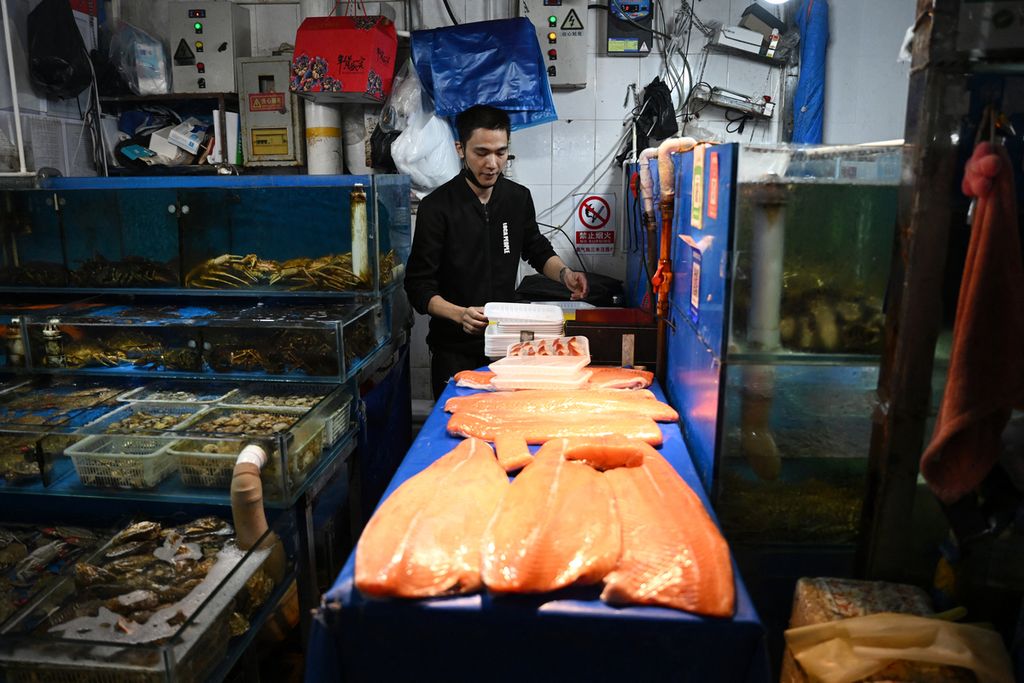 Seorang pedagang ikan menggelar dagangannya di sebuah kios di pasar ikan di Beijing, China, 24 Agustus 2023. Pelepasan limbah cair Pembangkit Listrik Tenaga Nuklir Fukushima Daiichi, Jepang, telah membuat hubungan diplomatik Jepang-China memanas. 