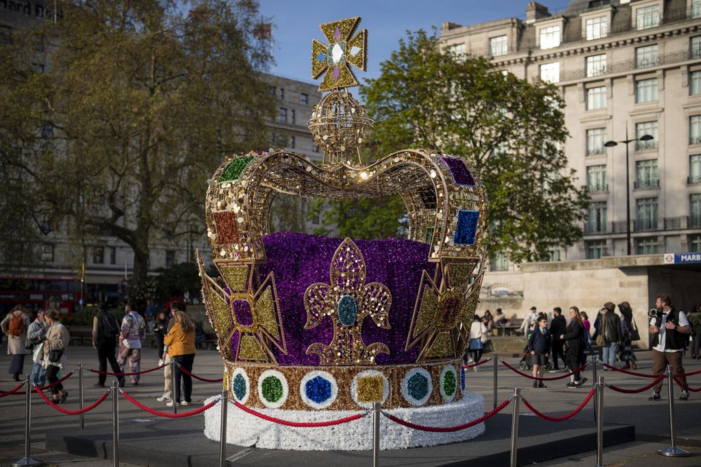 Orang-orang berjalan melewati instalasi seni yang menggambarkan mahkota St Edward di pusat kota London, Rabu (3/5/2023). Penobatan Raja Charles III akan berlangsung di Westminster Abbey pada 6 Mei 2023. 