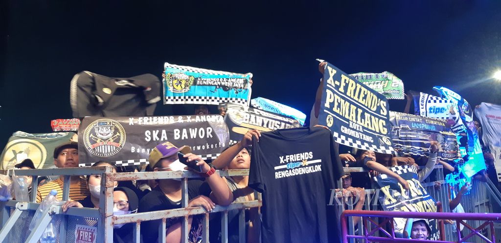 Penggemar Band Tipe-X memamerkan spanduk dan kaus yang menunjukkan identitas mereka di tengah acara konser Big Bang Jakarta 2022, di JIExpo Kemayoran, Jakarta Pusat, Sabtu (7/5/2022).