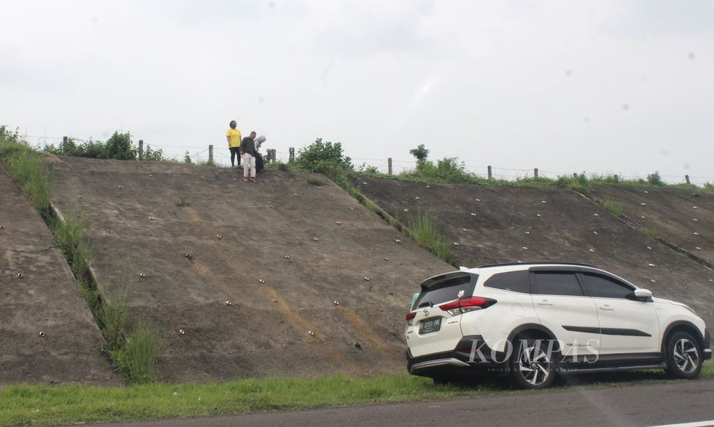 Pengendara mobil memanjat tembok penahan tanah di Tol Cikopo-Palimanan, Jumat (29/4/2022). 