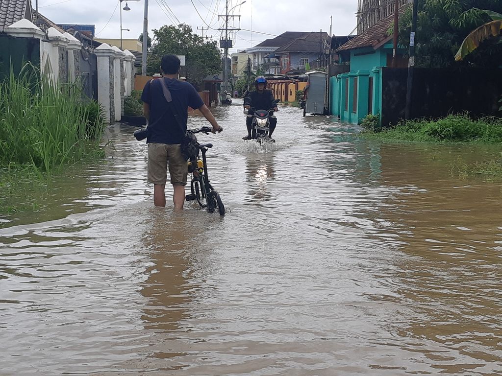 Banjir merendam kawasan permukiman penduduk di Kelurahan Pahlawan, Kecamatan Kemuning, Palembang, Sumatera Selatan, Sabtu (25/12/2021). Banjir disebabkan oleh meningkatnya intensitas curah hujan dan pasangnya air sungai.