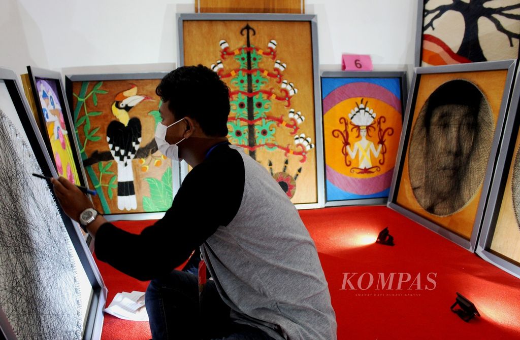 Salah satu peserta didik dari sekolah luar biasa di Kalteng menunjukkan karyanya melukis wajah dengan cara menyusun benang di Pameran Inovasi Pendidikan di Kalteng, Selasa (15/11/2022). Siang itu ia membuat beberapa sketsa wajah tokoh Indonesia dengan benang.