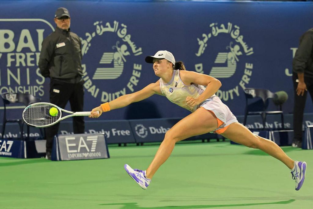 Petenis Polandia, Iga Swiatek, menjangkau bola saat menghadapi Leylah Fernandez (Kanada) pada babak kedua WTA 1000 Dubai, Selasa (21/2/2023). Swiatek menang 6-1, 6-1.