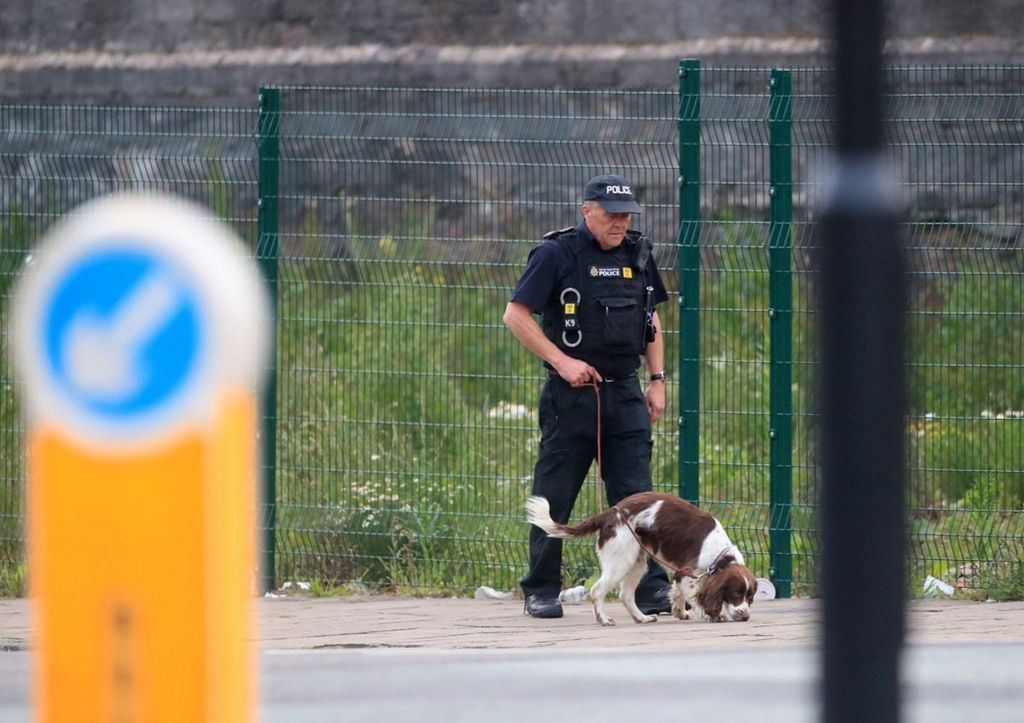 Seorang polisi bersama anjing pelacak berpatroli di dekat Manchester Arena, Manchester, Inggris, Selasa (23/5/2017).