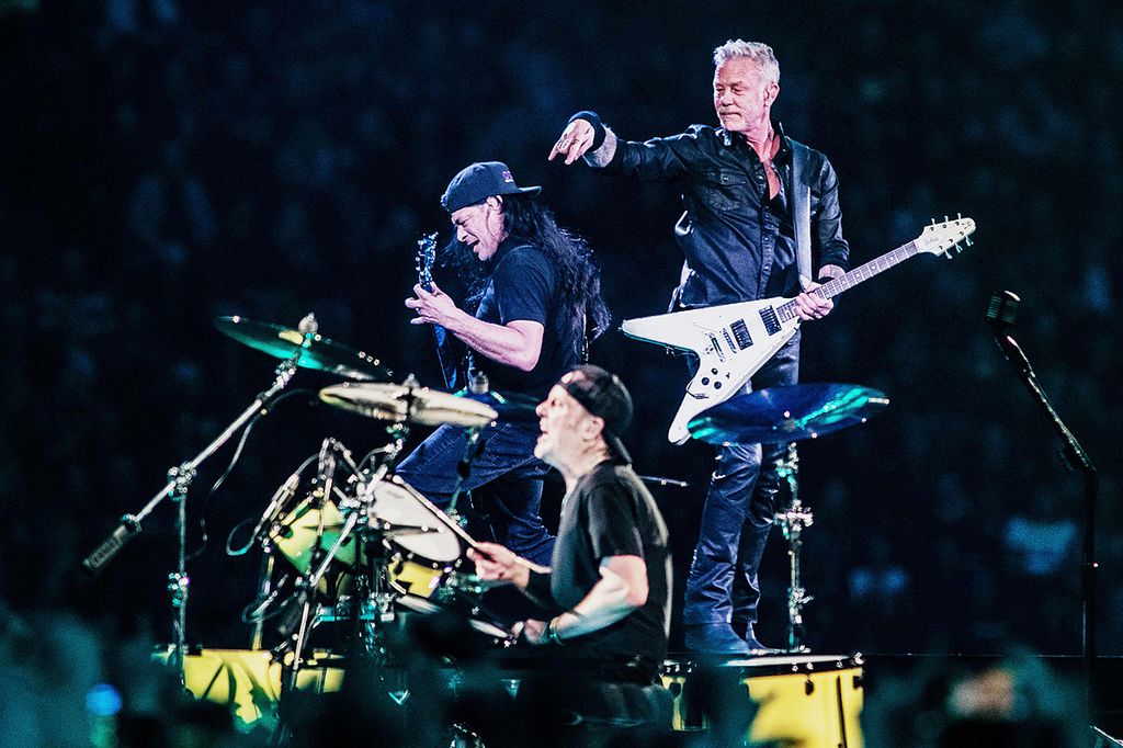 Band rock Metallica beranggotakan basis Robert Trujillo (paling kiri) penyanyi dan gitaris James Hetfield serta <i>drummer </i>Lars Ulrich tampil di panggung M27 World Tour di Johan Cruijff Arena, Amsterdam, Kamis (27/4/2023).
