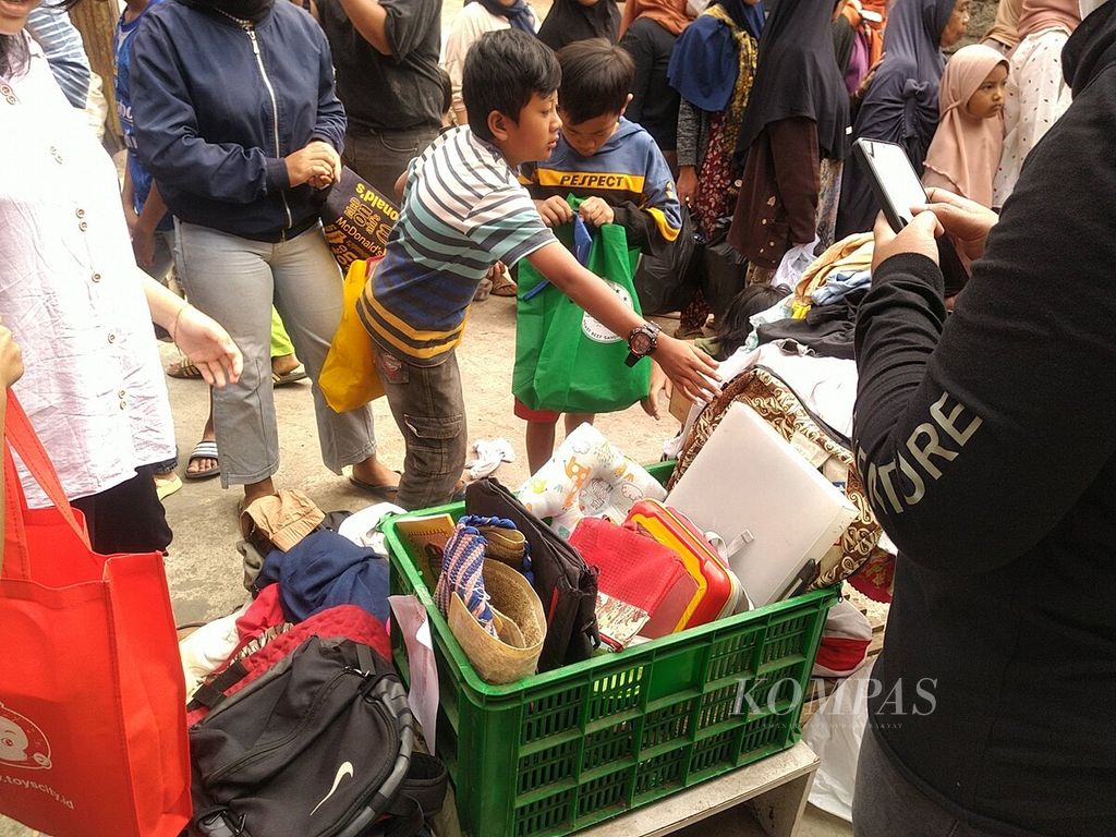 Peserta pasar barter di Kampung Cilalareun, Desa Cipanjalu, Kecamatan Cilengkrang, Kabupaten Bandung, Jawa Barat, memilih barang layak pakai yang didapat dari sejumlah donatur, Minggu (26/11/2023).