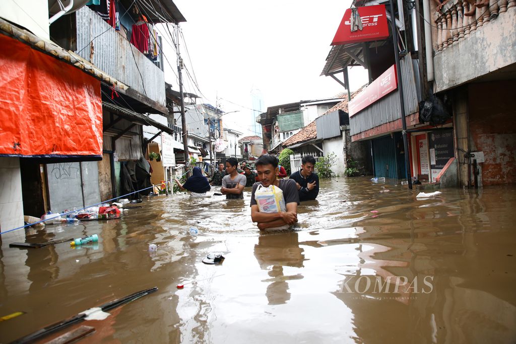 Warga menembus banjir akibat meluapnya Kali Krukut di kelurahan Karet Tengsin, Tanah Abang, Jakarta Pusat, Selasa (25/2/2020). Banjir akibat curah hujan yang tinggi ini tidak hanya merendam kawasan pemukiman namun juga memutus akses jalan di sejumlah wilayah di Jakarta, Bekasi, dan Tangerang.