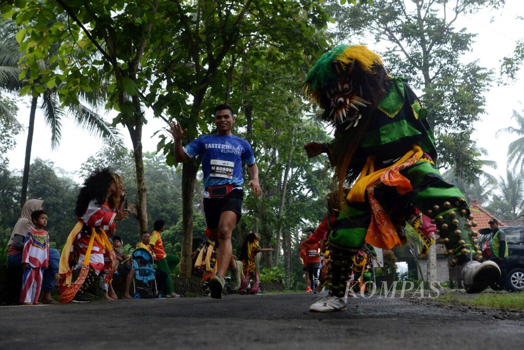 Peserta lomba lari Bank Jateng Borobudur Marathon 2017 dihibur kesenian tradisional saat melintas di Dusun Ngaran II, Desa Borobudur, Kecamatan Borobudur, Kabupaten Magelang, Jawa Tengah, Minggu (19/11/2017).