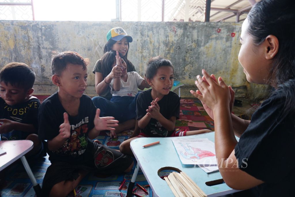 Anak-anak pedagang Pasar Bersehati Manado, Sulawesi Utara, mengikuti kelas informal mingguan yang diselenggarakan Komunitas Dinding Manado di lantai 3 gedung utama pasar, Sabtu (11/11/2023). Selama 13 tahun, Komunitas Dinding Manado konsisten mendampingi anak-anak di pasar karena mulanya banyak yang tak bersekolah.