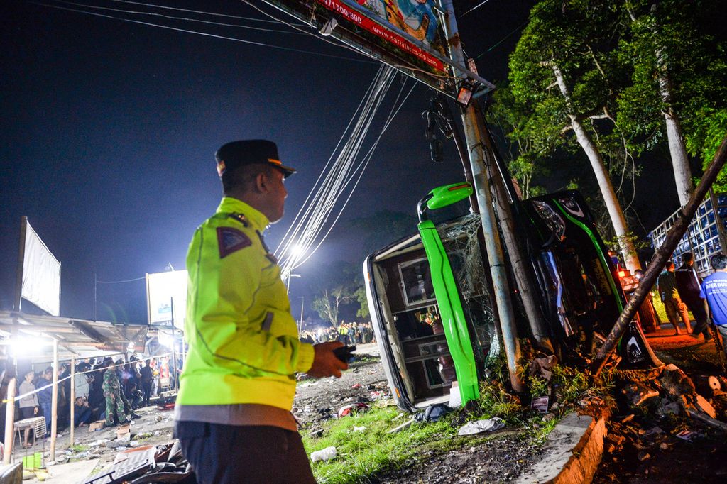 Petugas kepolisian berdiri di samping bangkai bus yang terlibat kecelakaan di Desa Palasari, Kecamatan Ciater, Kabupaten Subang, Jawa Barat, Sabtu (11/5/2024). 