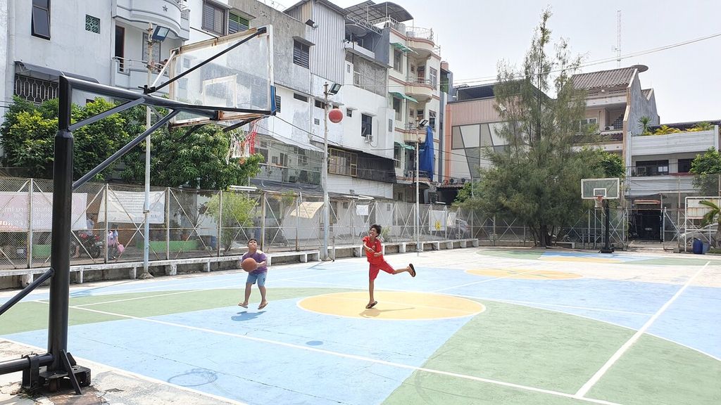 Anak-anak bermain basket di Lapangan Kebon Torong, Jalan Kemurnian Selatan. RT 013, RW 001, Glodok, Tamansari, Jakarta Barat. Warga menolak rencana Dinas Kesehatan DKI Jakarta untuk membangun puskesmas di lapangan ini.