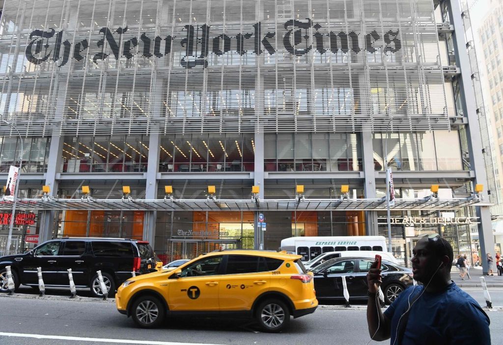 Seorang pria memegang gawai pintar di depan gedung surat kabar <i>The New York Times</i> di New York, Amerika Serikat, 6 September 2018. 