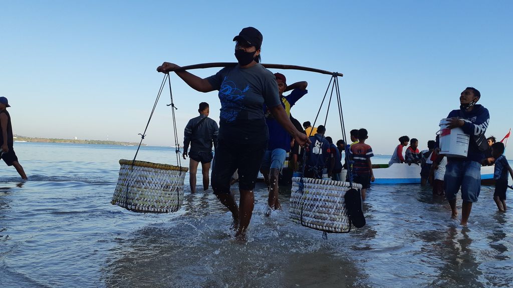 Perempuan pedagang ikan baru saja membeli ikan dari perahu nelayan di Pantai Oesapa, Kota Kupang, Nusa Tenggara Timur, Rabu (18/8/2021). Banyak perempuan di daerah itu yang menjual ikan.