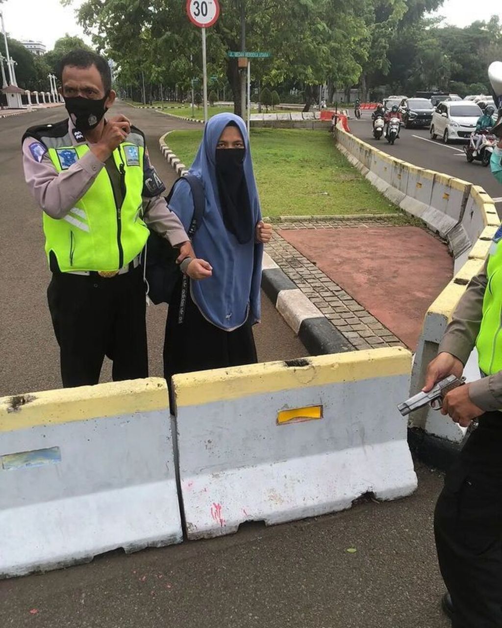 Anggota polisi lalu lintas mengamankan seorang perempuan yang menodongkan senjata api ke petugas pengawal Istana Merdeka, Jakarta Pusat, Selasa (25/10/2022) pagi.