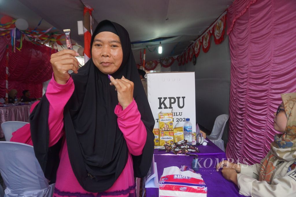 Warga menunjukkan cokelat seusai mencoblos di TPS 10 Desa Klahang, Kecamatan Sokaraja, Kabupaten Banyumas, Jawa Tengah, Rabu (14/2/2024). TPS ini didesain dengan tema Valentine Day. 