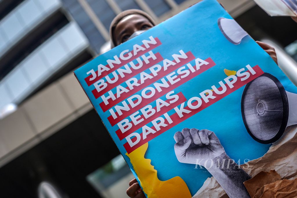 Seorang aktivis yang tergabung dalam Gerakan #BersihkanIndonesia, Perempuan Indonesia Anti-Korupsi, BEM SI, dan beberapa perwakilan organisasi lain menggelar aksi di depan Gedung Merah Putih Komisi Pemberantasan Korupsi (KPK), Jakarta, Selasa (9/11/2021). 