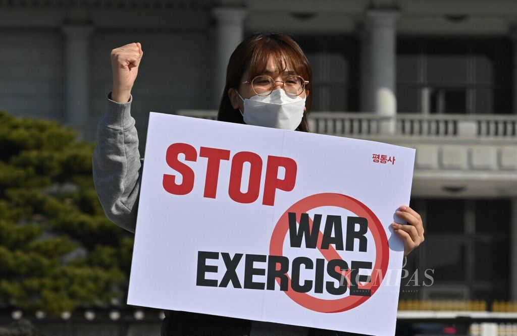 Pegiat antiperang membawa poster bertujuan Hentikan Latihan Perang” dalam unjuk rasa menentang latihan bersama militer Korea Selatan dan Amerika Serikat. Mereka berunjuk rasa di depan kantor presiden Korsel, Gedung Biru, di Seoul pada 8 Maret 2021.     