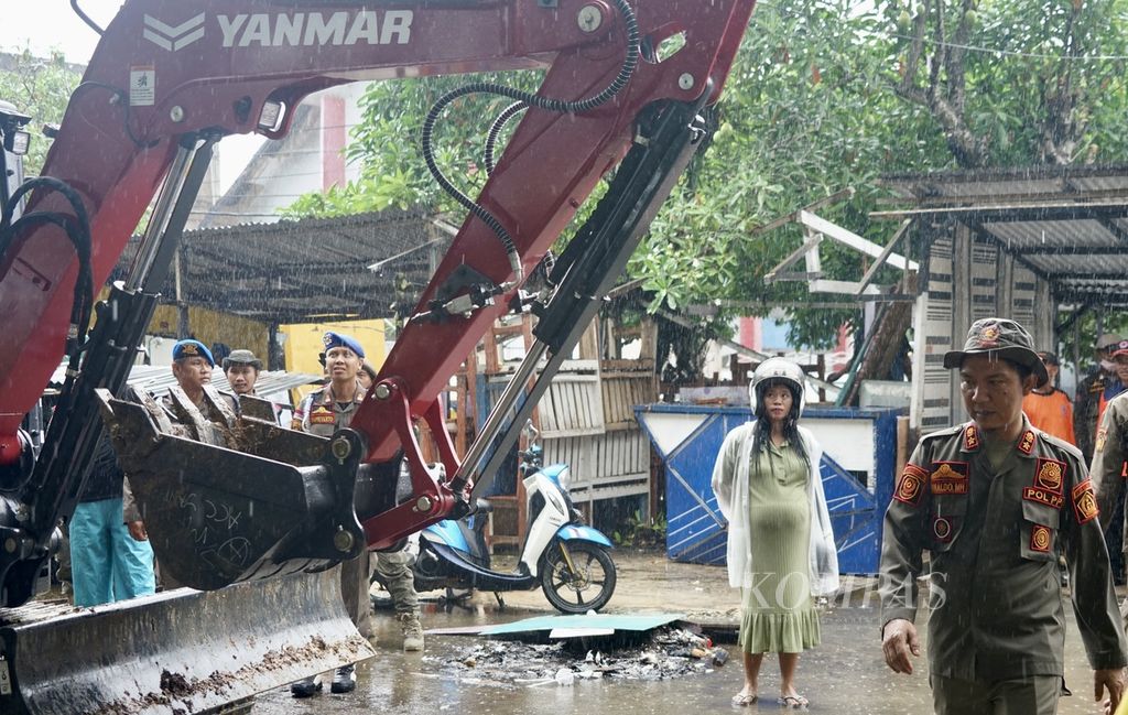 Seorang pedagang termenung saat melihat lapaknya akan dirobohkan petugas di Tugu Religi Kendari, Sulawesi Tenggara, Rabu (22/5/2024). Ratusan pedagang di kawasan ini kehilangan tempat akibat dibongkar paksa oleh Pemkot Kendari.