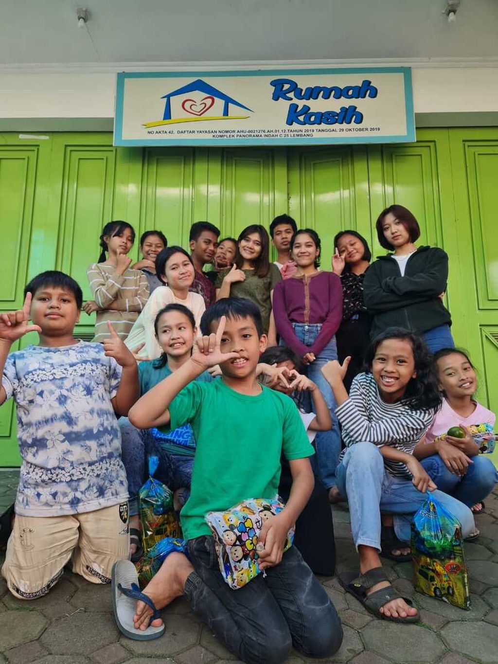 Merry Elizabeth (21)  foster child of Rumah Kasih Orphanage, Lembang, West Java (far right back, black jacket) taking a photo with the orphanage children. Even though all her life she lived in an orphanage, it did not dampen Elizabeth's determination to go to school. This year he graduated from college and has been accepted to work in Singapore.