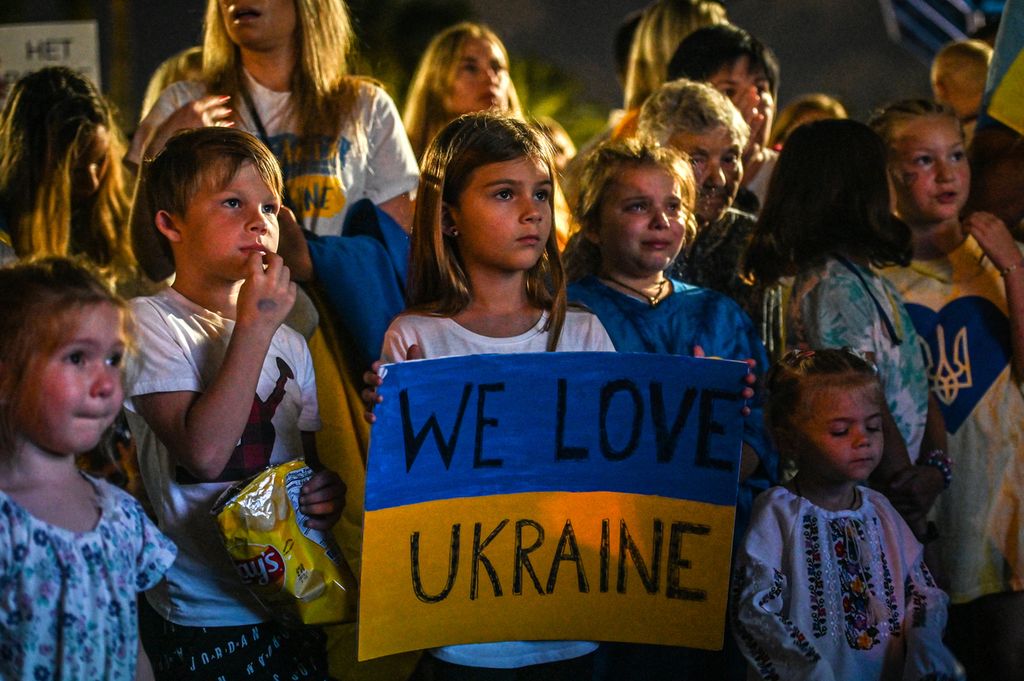Anak-anak berkumpul untuk memperingati satu tahun invasi Rusia ke Ukraina, di Pantai Hallandale, Florida, AS, 24 Februari 2023.