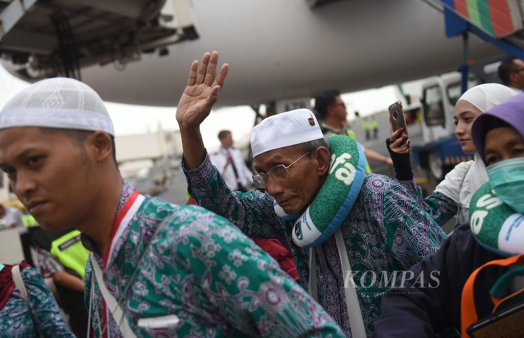 Jemaah haji kloter 1 asal Kabupaten Bangkalan, melambaikan tangan saat tiba di Bandara Juanda Surabaya, Sidoarjo, Jawa Timur, Selasa (4/7/2023).