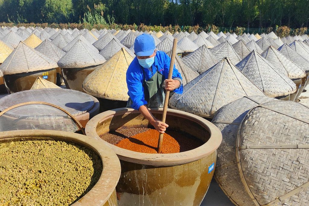 Dalam foto yang diambil pada Rabu (19/10/2022) tampak seorang pekerja tengah mengaduk kedelai yang difermentasi untuk membuat kecap. Foto diambil di Rugao, Provinsi Jiangsu, China.