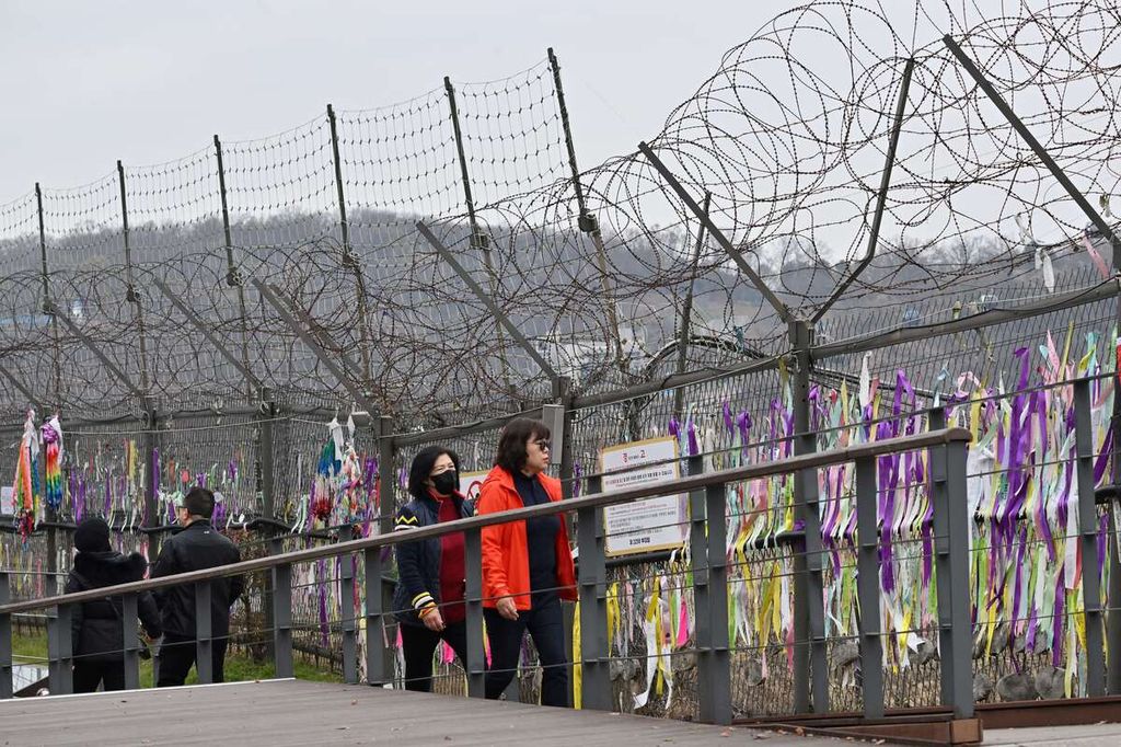 Para pengunjung berjalan melewati pagar militer di taman perdamaian Imjingak dekat zona demiliterisasi (DMZ) yang membagi Korsel dan Korut di Paju pada 22 November 2023.