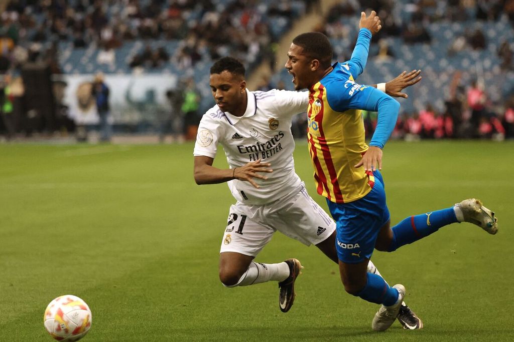 Pemain Real Madrid Rodrygo berebut bola dengan pemain Valencia Samuel Lino pada semifinal Piala Super Spanyol di Stadion Internasional King Fahd, di Riyadh, Arab Saudi, Kamis (12/1/2023) dini hari WIB. Madrid menang dengan skor 4-3 (1-1) dalam adu penalti dan Lino mencetak satu gol bagi Valencia. 