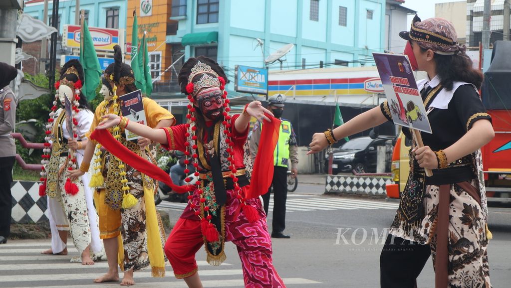 Sejumlah pegiat seni menari topeng Cirebon untuk menyosialisasikan keselamatan berkendara di perempatan Palimanan, Kabupaten Cirebon, Jawa Barat, Selasa (7/2/2023). 
