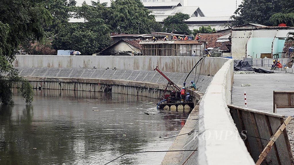 Pekerja  menyelesaikan normalisasi bantaran Sungai Ciliwung yang memasuki tahap pengecoran jalan inspeksi dan pengerjaan turap kali di Bukit Duri, Tebet, Jakarta Selatan, Selasa (24/10). Penataan kawasan bantaran  Ciliwung merupakan salah satu proyek untuk mengendalikan banjir di Jakarta.