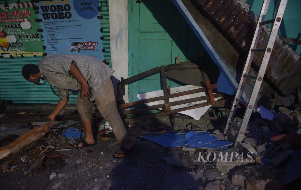 Petugas mengecek bagian bangunan yang rusak di Jalan Ngaglik pascagempa di Surabaya, Jumat (22/3/2024).