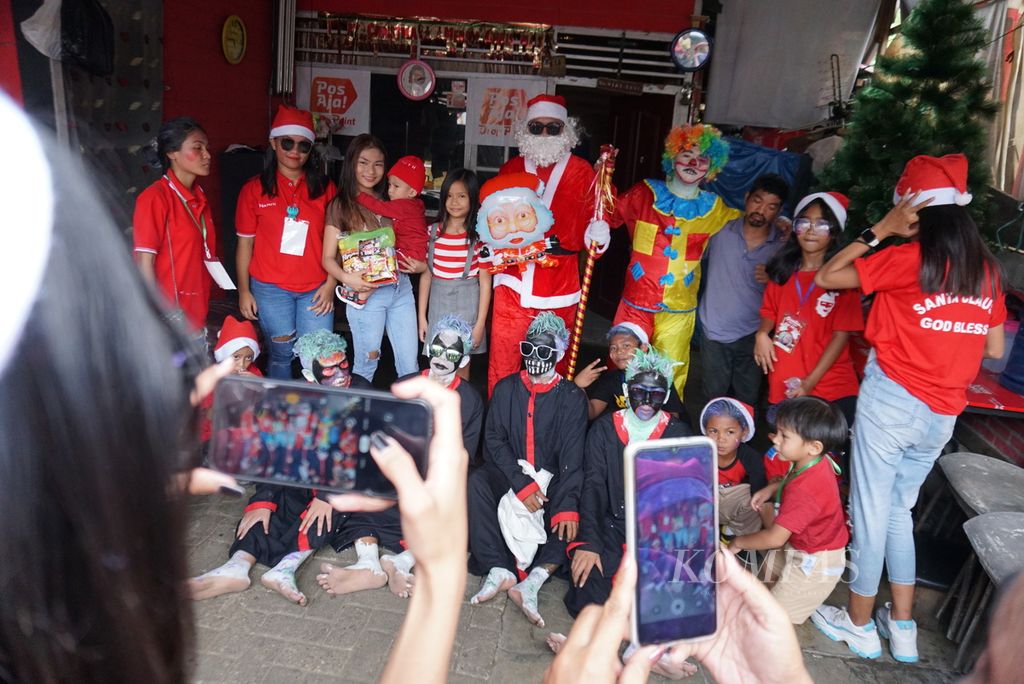 Santa Claus and black piet from the Santa Claus God Bless Committee group visited a resident's house to give a gift to a child at Paal IV, Manado, North Sulawesi, Saturday (10/12/2022)..