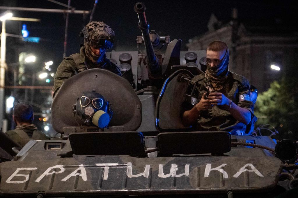 Anggota pasukan tentara bayaran Wagner Group duduk di atas kendaraan militer, yang bertuliskan "Saudara" di Rostov-on-Don, Rusia, Sabtu (24/6/2023) malam. 