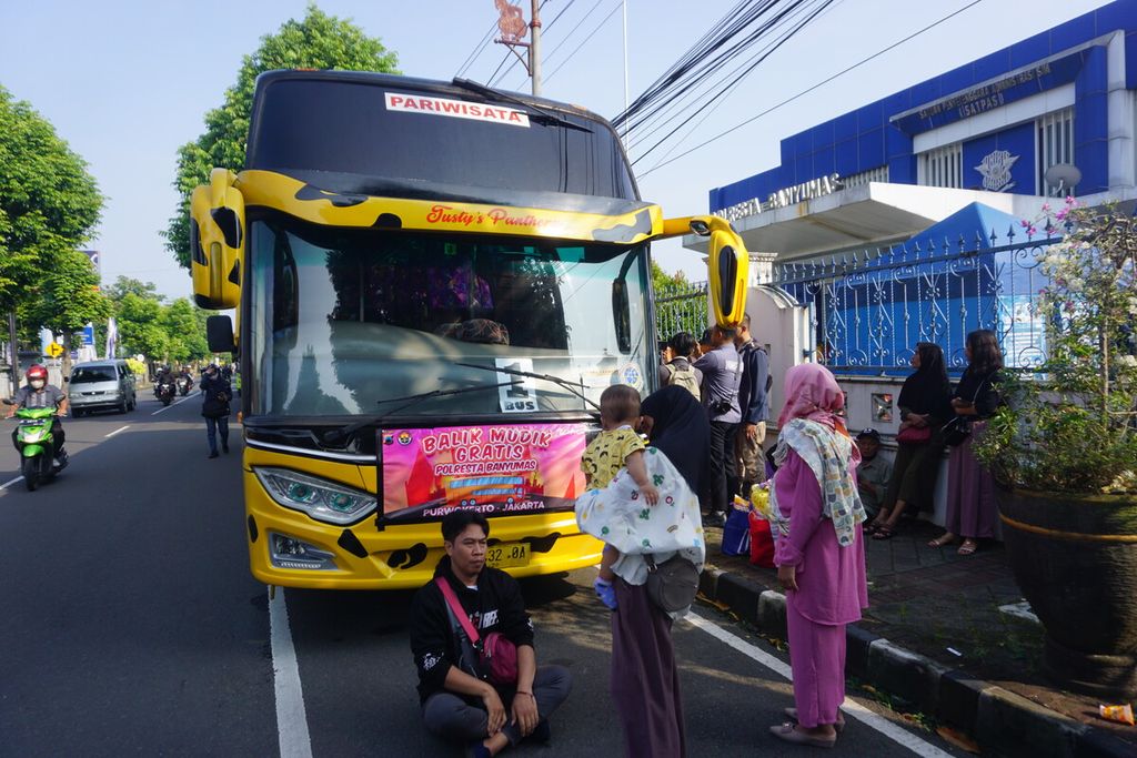 Keluarga pemudik menunggu keberangkatan bus dalam program balik mudik gratis yang digelar Polresta Banyumas dari Purwokerto ke Jakarta, Rabu (26/4/2023).