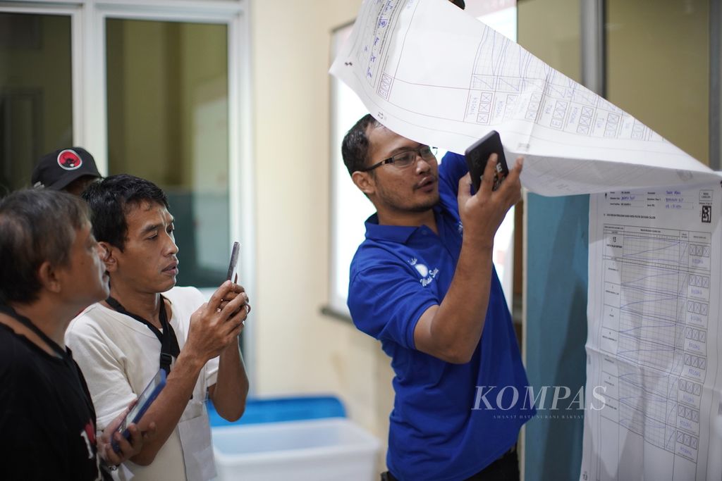 Saksi memotret dengan telepon genggam rekapitulasi hasil penghitungan suara tingkat kecamatan di Gelanggang Remaja Kecamatan Tanah Abang, Jakarta Pusat, Senin (19/2/2024).