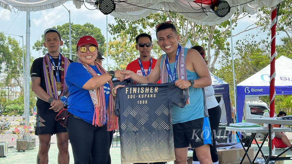 Direktur Eksekutif Plan Indonesia Dini Widiastuti menyerahkan medali dan kaos penamat kepada Wanda Oktavia, pelari asal Padang yang finis dalam lari amal ultramaraton Jelajah Timur 2023 di Kantor Gubernur NTT di Kota Kupang, Sabtu (28/10/2023). 